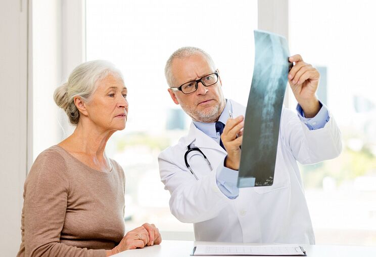 El médico determina la osteocondrosis cervical en un paciente mediante radiografía.
